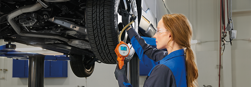 A Subaru technician checking tire pressure. | Marin Subaru in San Rafael CA