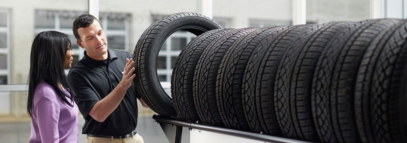 Subaru service representative showing customer a tire. | Marin Subaru in San Rafael CA
